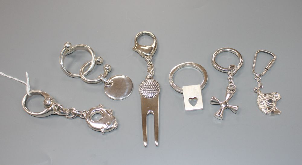 Seven assorted modern silver keyrings including novelty pig and horses head,